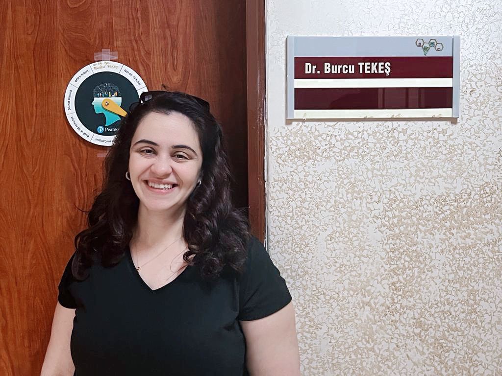Photo of Doctor Burcu Tekes in front of  office door with her name sign next to the door