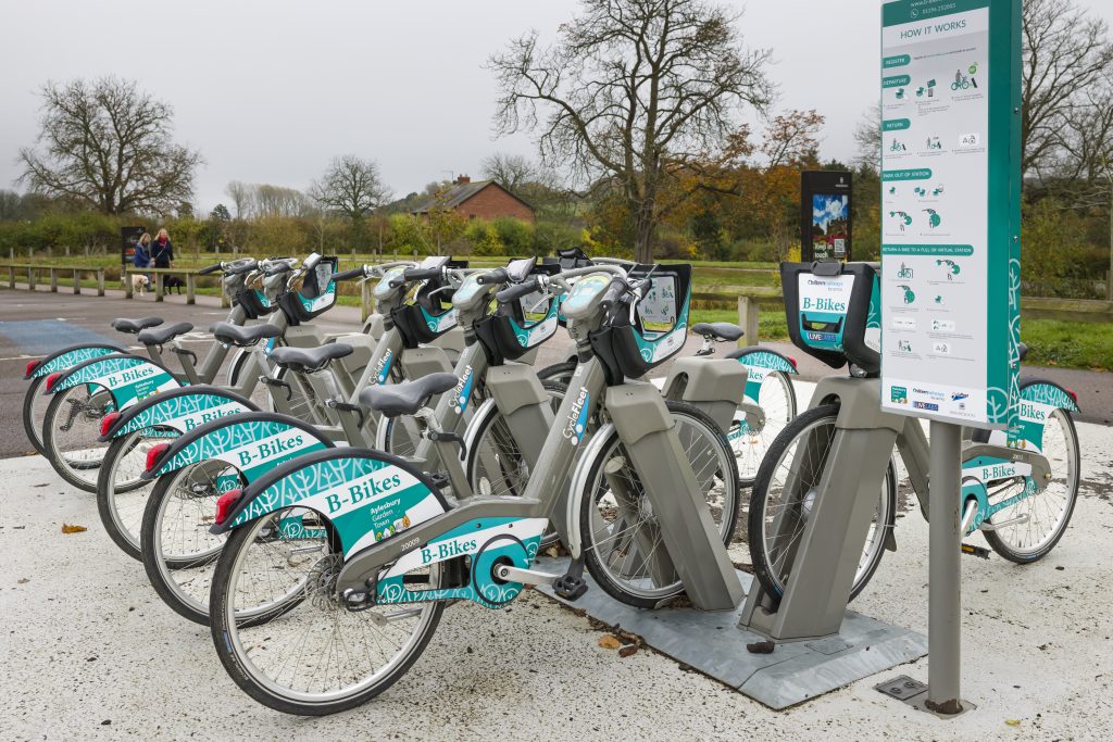 Row of electric bikes, e-bikes at a charging station. Electrical ebike hire, rental.