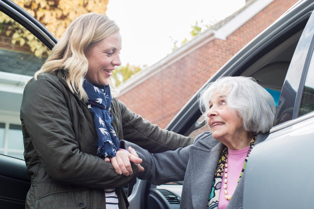 Female Neighbour Giving Senior Woman A Lift In Car